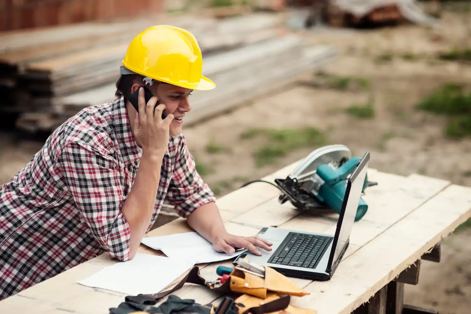 Person using phone and laptop outdoors