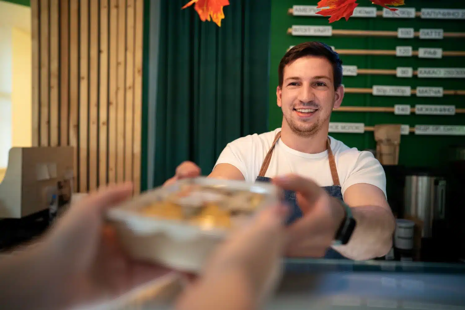 Smiling worker handing food to customer