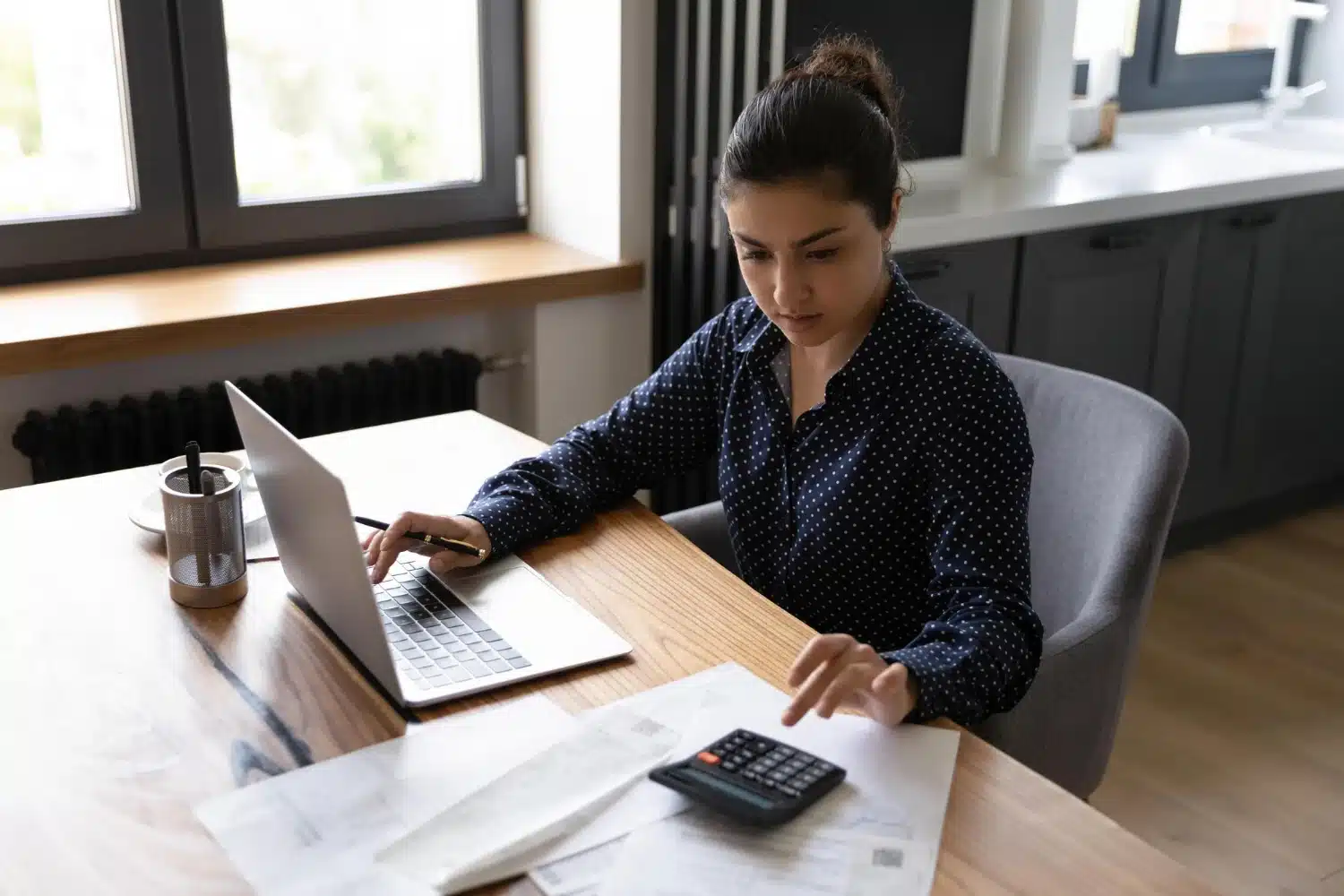 Woman calculating finances at desk